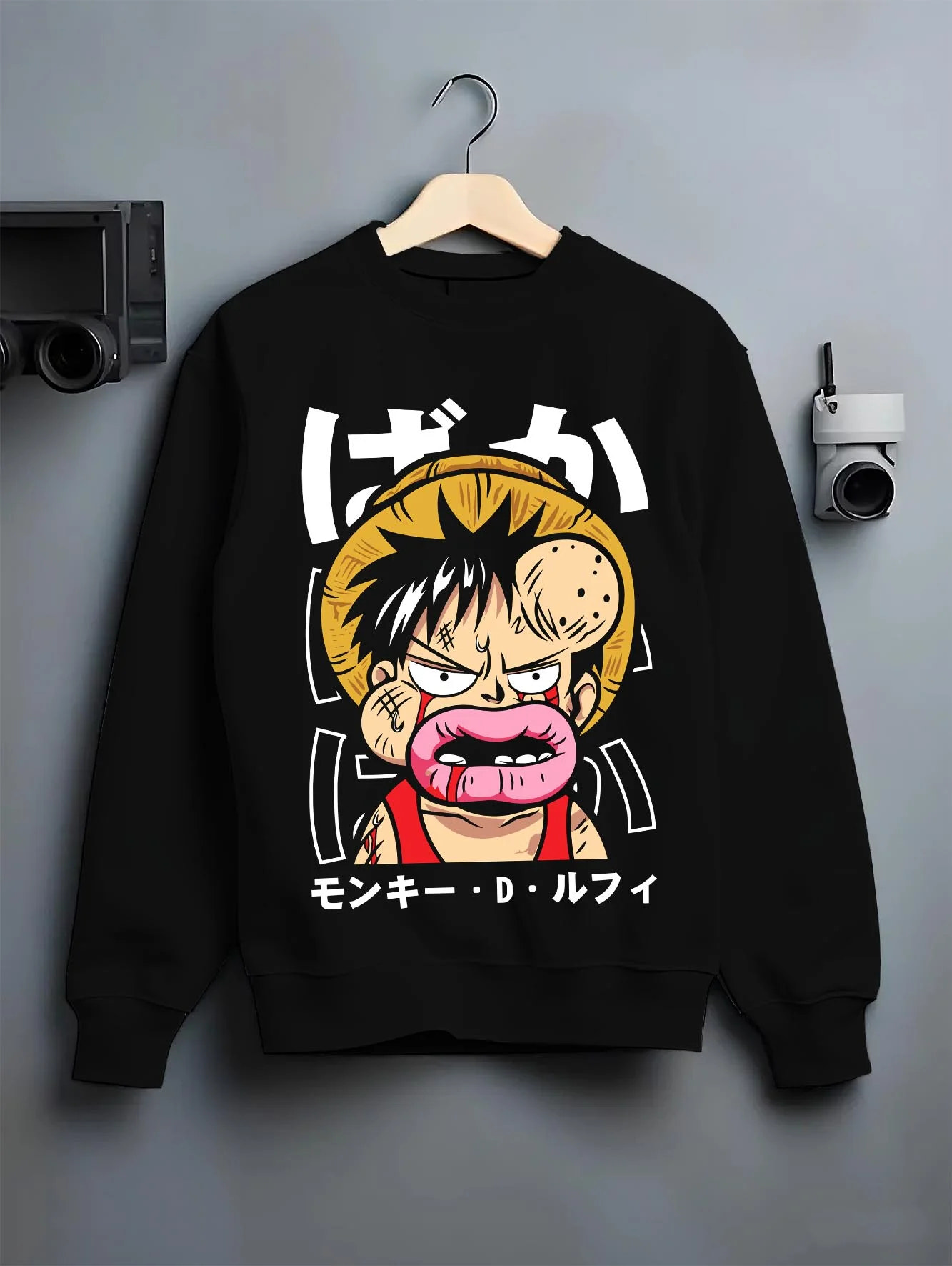 Black crewneck sweatshirt on hanger with Monkey D Luffy Hoodie One Piece Funny Face graphic premium wear.