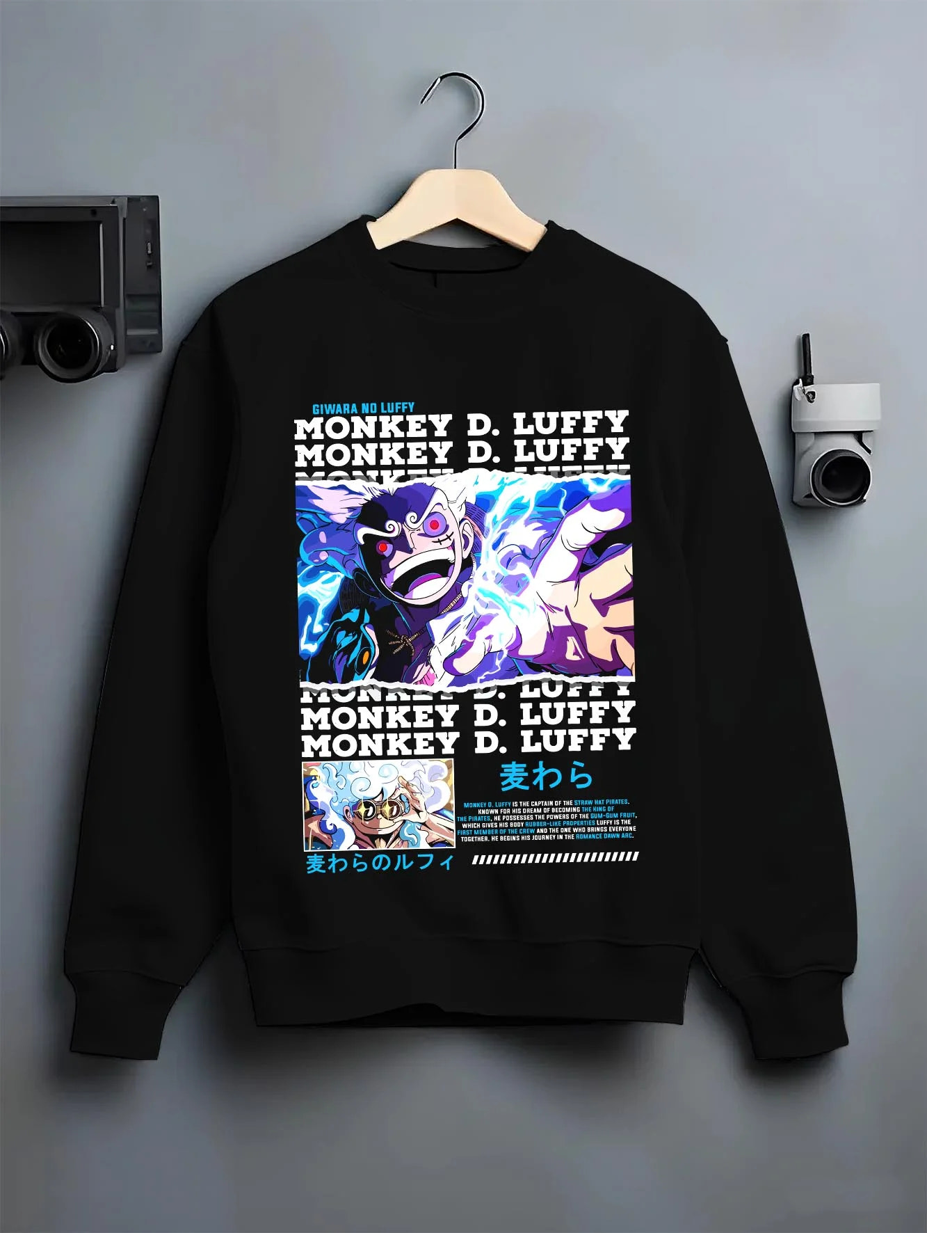 Black crewneck sweatshirt on hanger with Monkey D Luffy Hoodie One Piece Gum Gum Gear graphic streetwear graphic.
