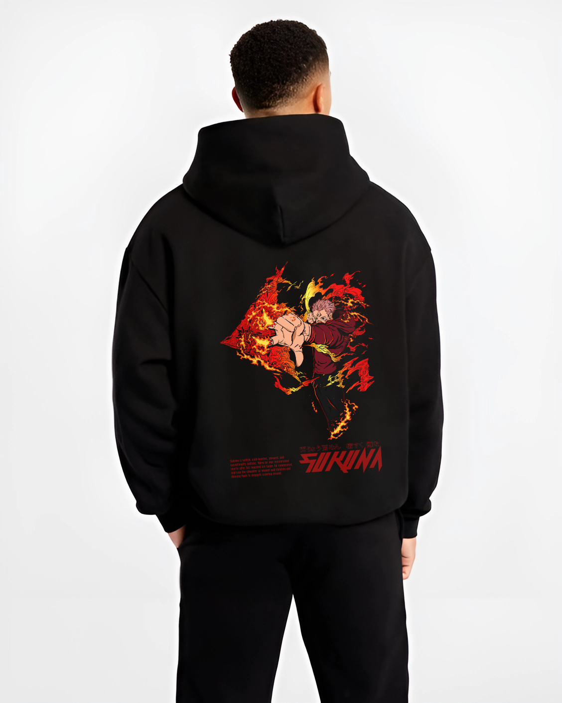 Black hoodie worn by a male model, back view, featuring Jujutsu Kaisen Sukuna shonen battle character artwork with flames and cursed energy in bold anime poster style.