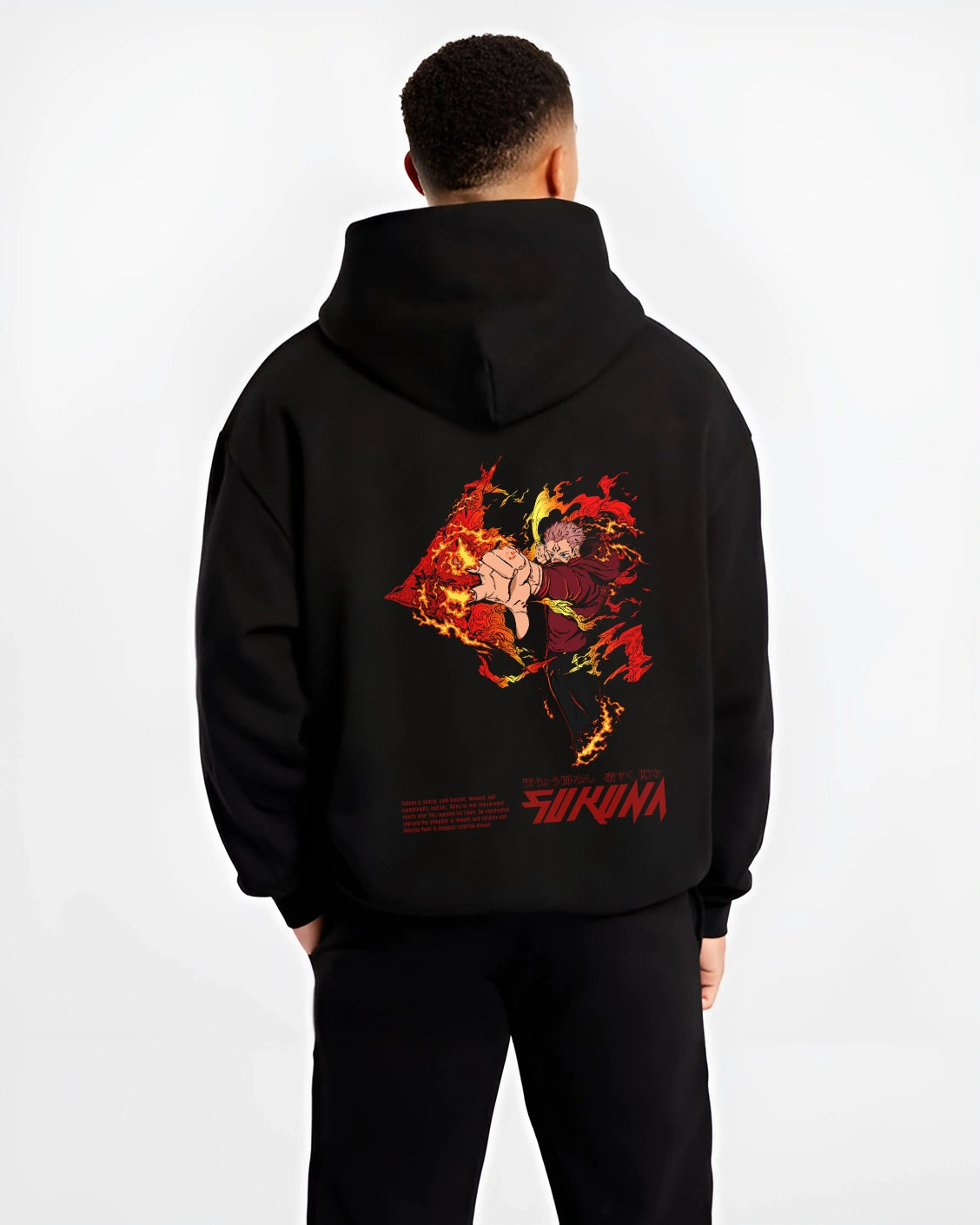 Male model wearing black Jujutsu Kaisen Sukuna hoodie with fiery cursed energy artwork, Kunai anime clothing inspired by Ryomen Sukuna’s domain expansion.
