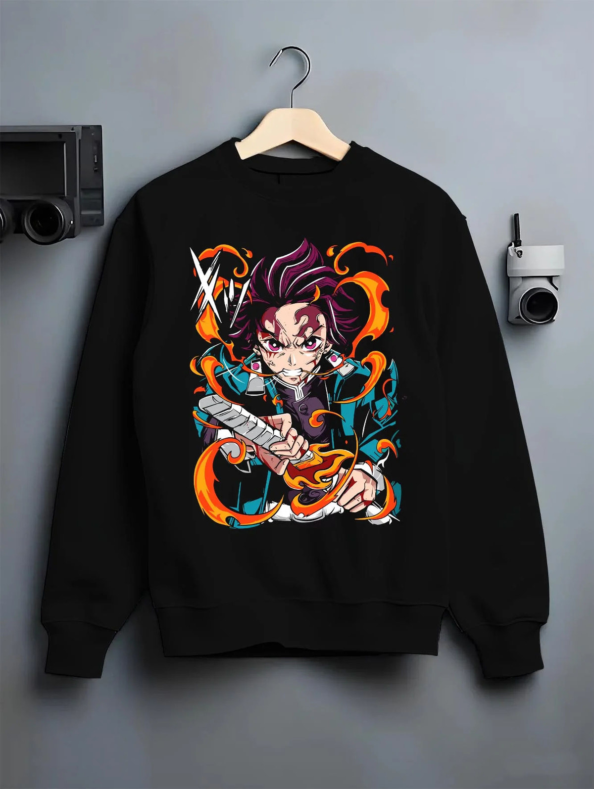 Black crewneck sweatshirt on hanger featuring Tanjiro Kamado Hinokami Kagura flame sword Demon Slayer artwork.