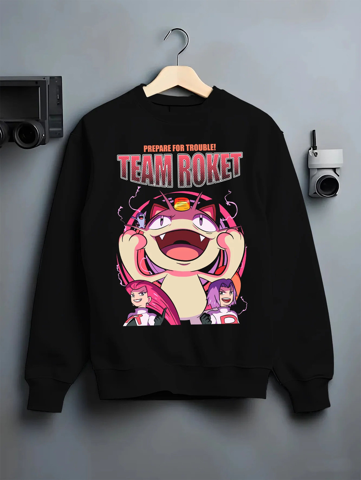 Black crewneck sweatshirt on hanger with Team Rocket Jessie, James and Meowth from Pokémon illustrated back graphic