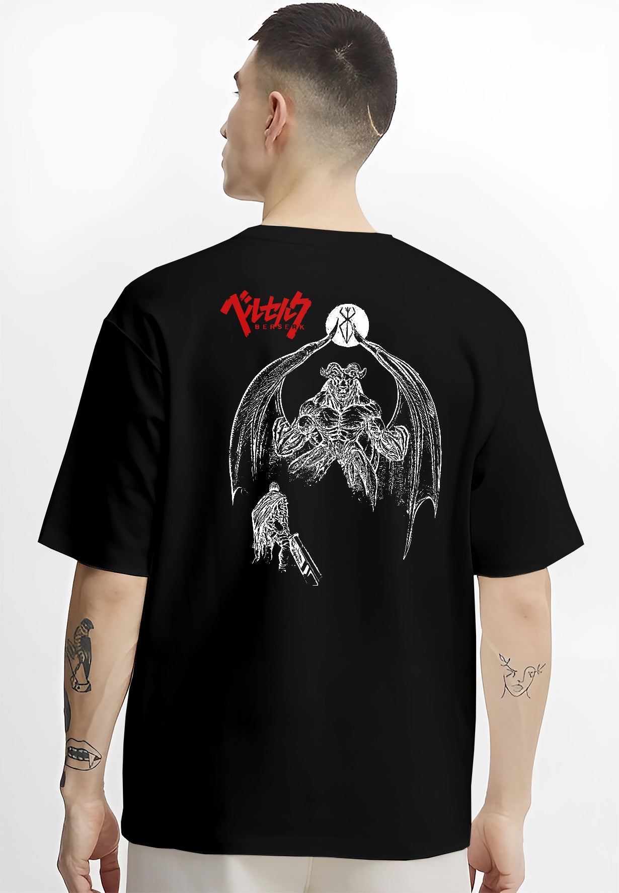 Black T-shirt worn by a male model, back view, featuring Berserk Guts dark manga panel artwork with towering apostle demon and detailed shonen battle style.