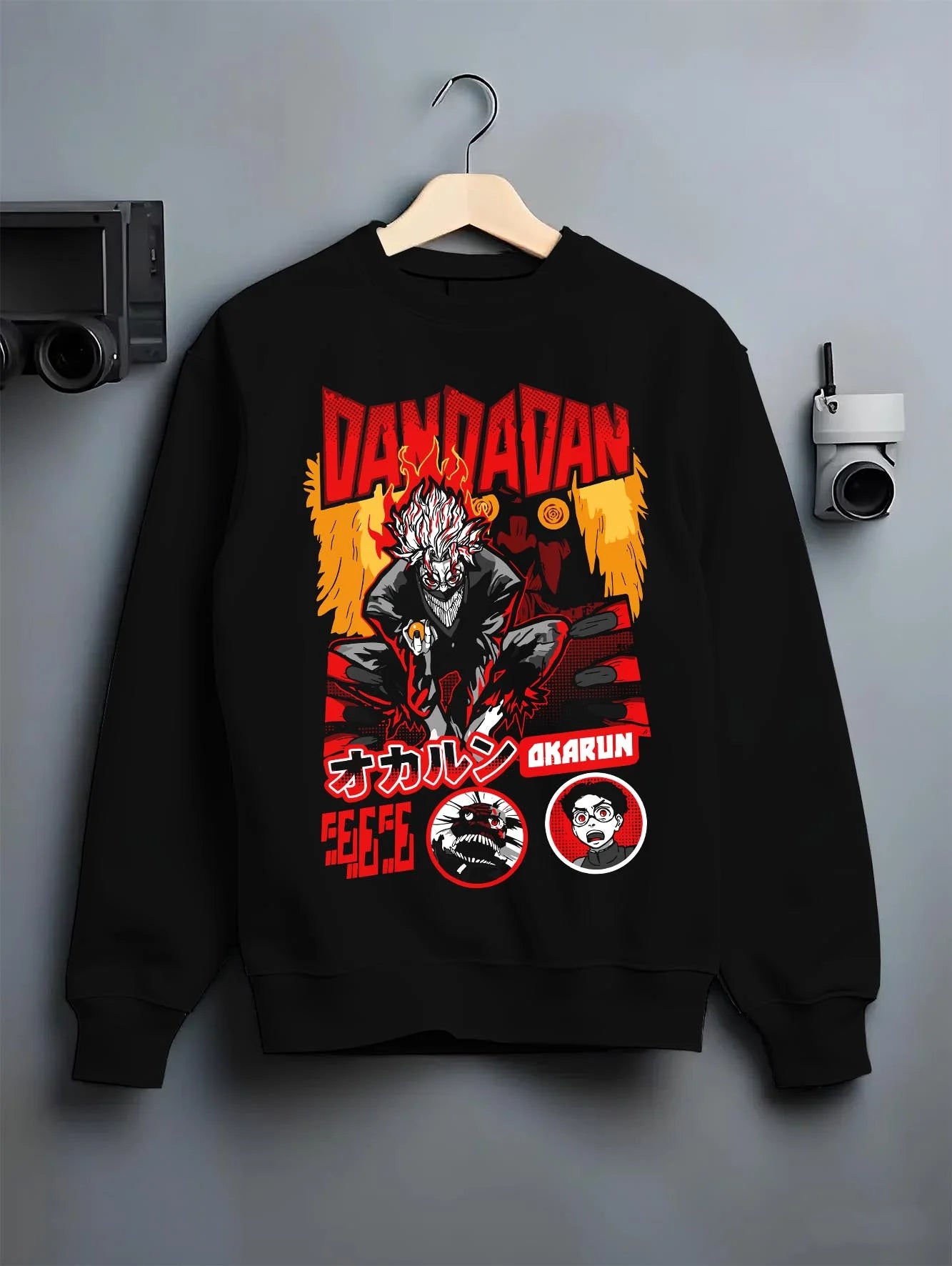 Black crewneck sweatshirt on hanger with Okarun Hoodie Dandadan Possessed Spirit Alien Fight graphic premium wear.