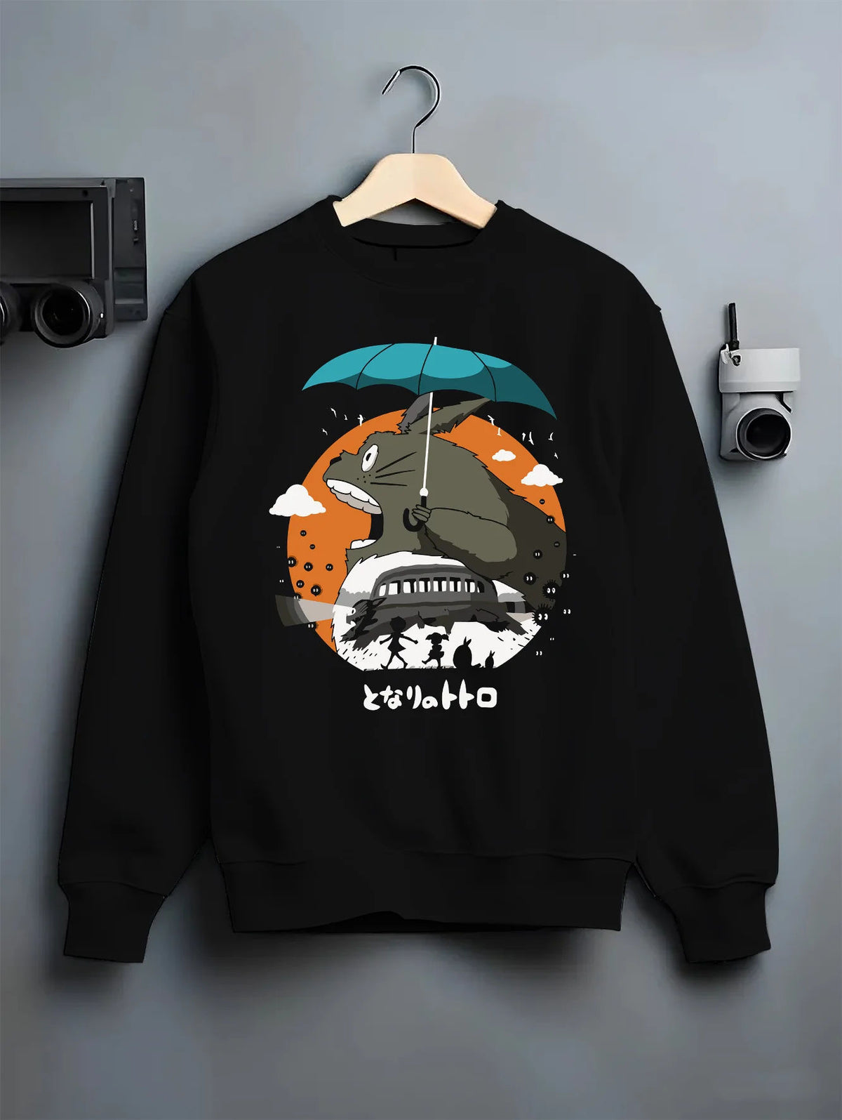 Black crewneck sweatshirt on hanger with Totoro with umbrella and woodland house from My Neighbor Totoro / Studio Ghibli