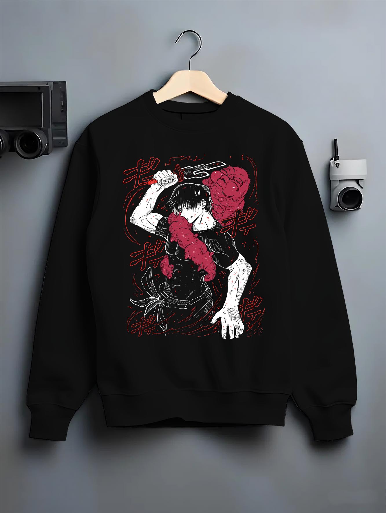 Black crewneck sweatshirt on a hanger against a grey wall, featuring Jujutsu Kaisen Yuta Okkotsu anime poster inspired artwork with cursed sword in retro manga panel style.