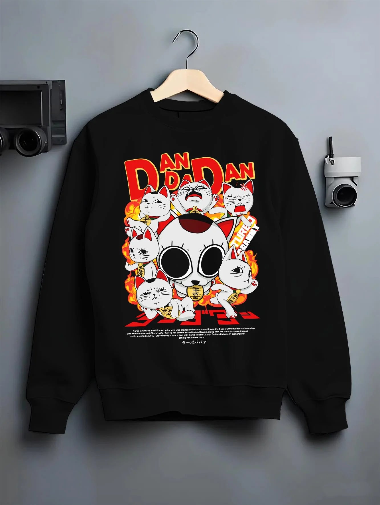 Black crewneck sweatshirt on hanger with Turbo Granny Hoodie Dandadan Lucky Cat Spirit Anime graphic bold anime graphic.