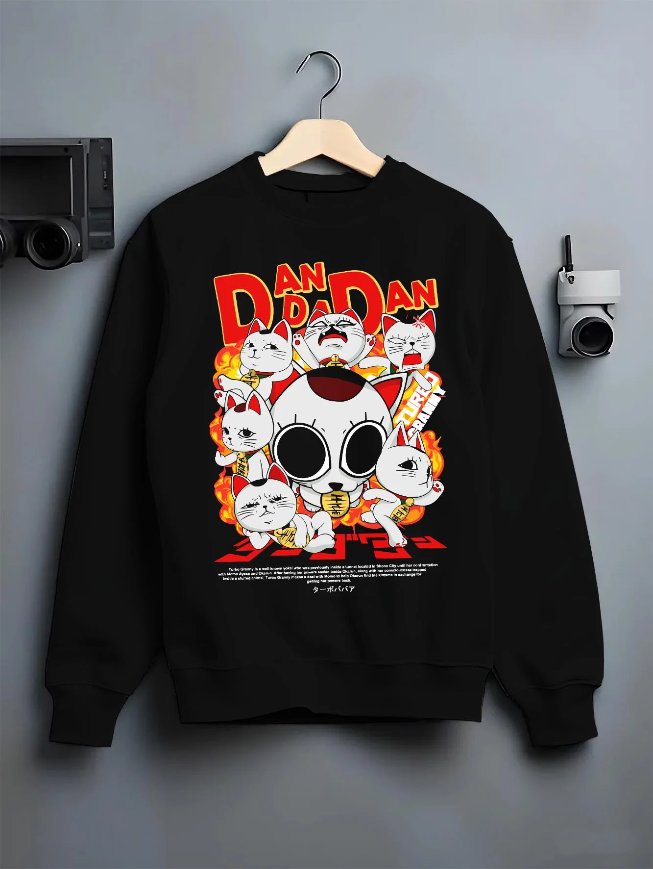 Black crewneck sweatshirt on hanger with Turbo Granny Hoodie Dandadan Lucky Cat Spirit Anime graphic bold anime graphic.