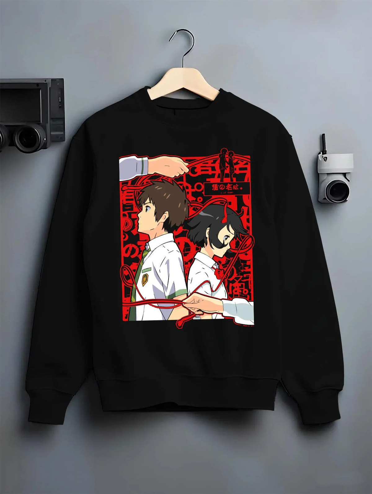 Black crewneck sweatshirt on hanger featuring Taki and Mitsuha red thread Your Name artwork.