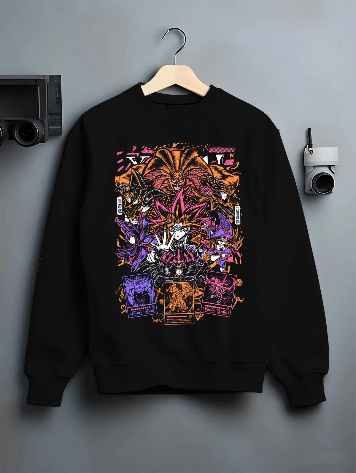 Black crewneck sweatshirt on hanger with Yu-Gi-Oh! monsters and duelling cards collage illustrated back graphic