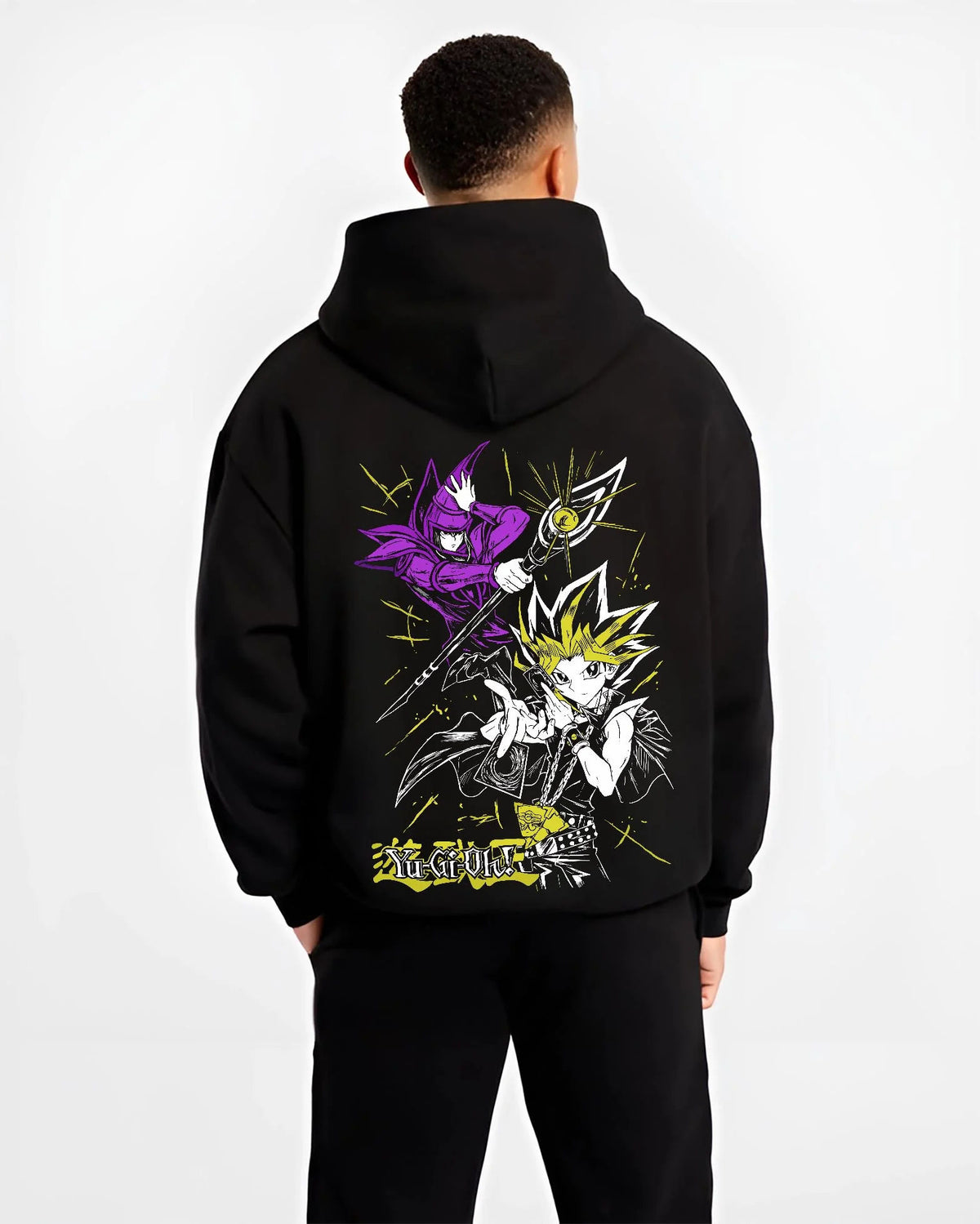 Black hoodie worn by male model from the back featuring Yugi Millennium Puzzle King of Games Yu-Gi-Oh! artwork.