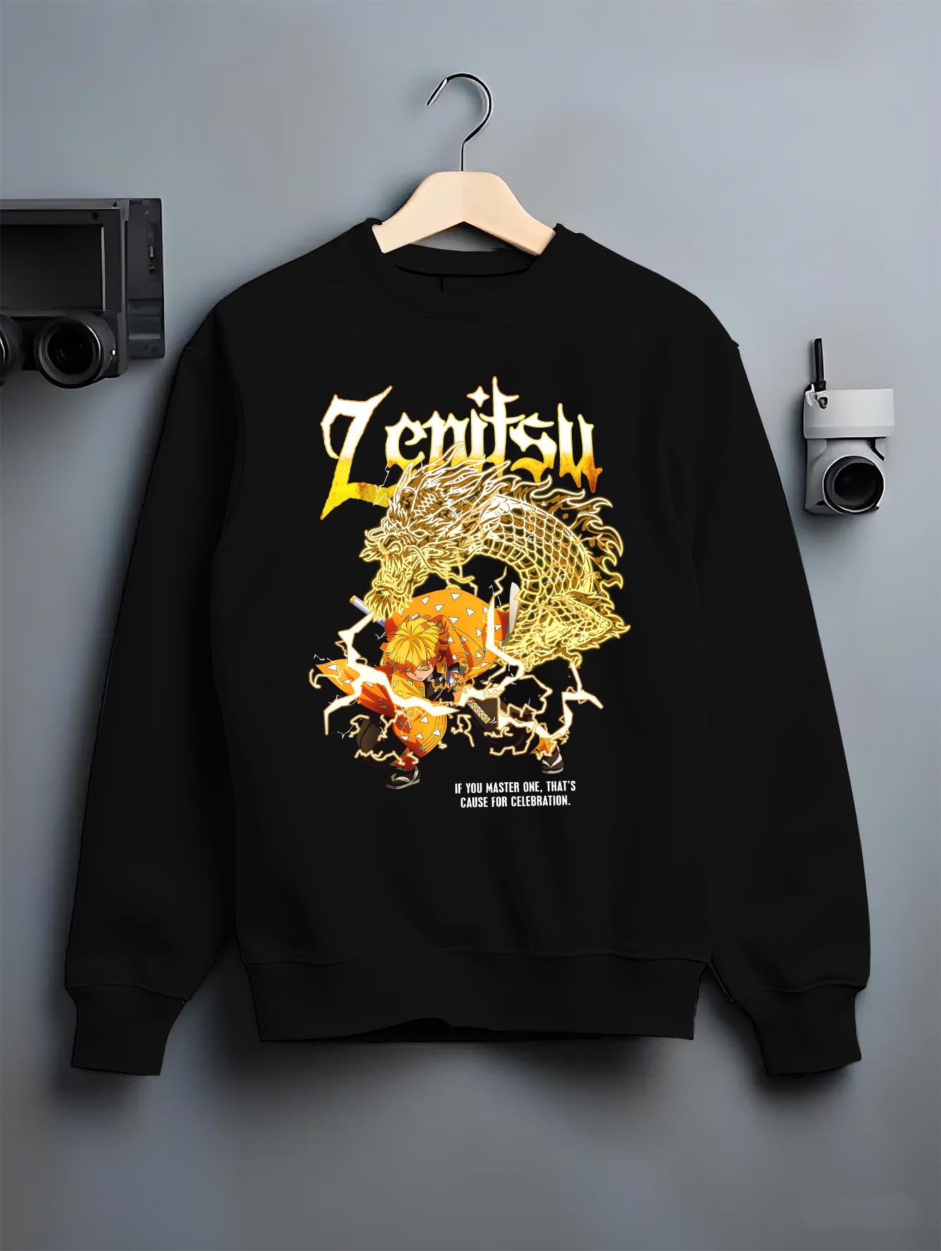 Black crewneck sweatshirt on a hanger against a grey wall, featuring Zenitsu Demon Slayer shonen battle character artwork in retro streetwear graphic anime poster inspired design.
