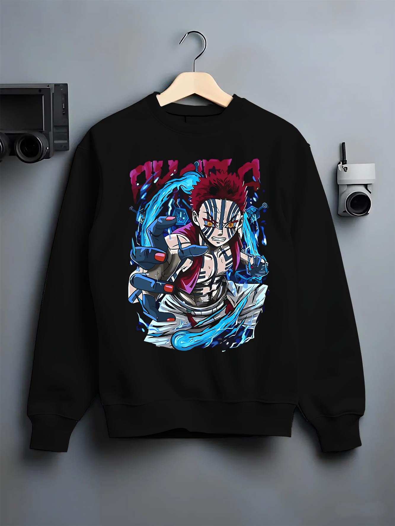 Black crewneck sweatshirt on a hanger against a grey wall, featuring Akaza Demon Slayer cyberpunk anime aesthetic graphic with glowing battle aura and sharp manga detail.