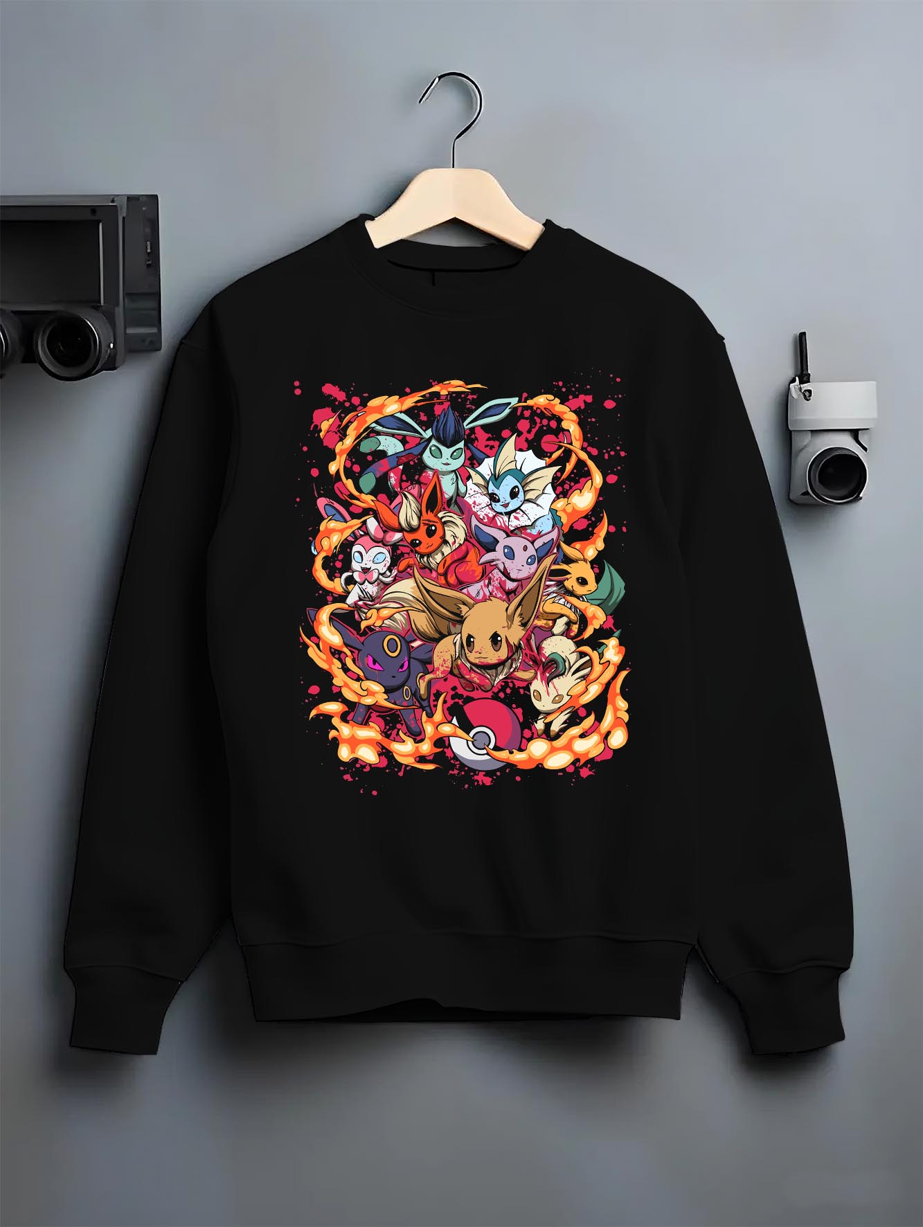 Black crewneck sweatshirt on hanger against grey wall, Eevee evolutions anime collage with flame ring and retro streetwear vibe.