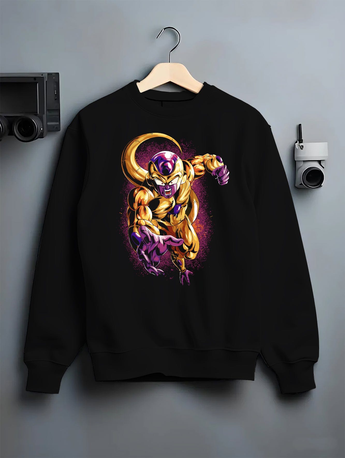 Black crewneck sweatshirt on a hanger against a grey wall, featuring Frieza Golden Form Dragon Ball Z retro manga graphic with glowing purple aura and bold villain artwork.