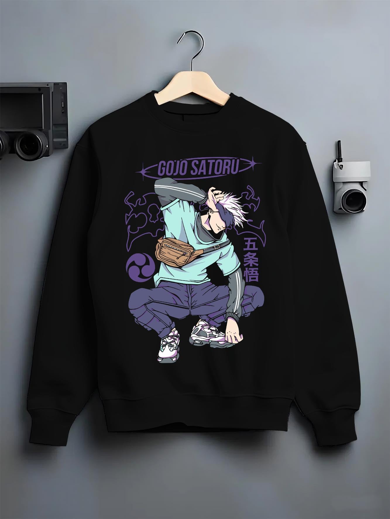 Black crewneck sweatshirt on hanger against grey wall, Gojo Satoru urban fashion back design with purple lettering, dynamic pose and clean manga styling.