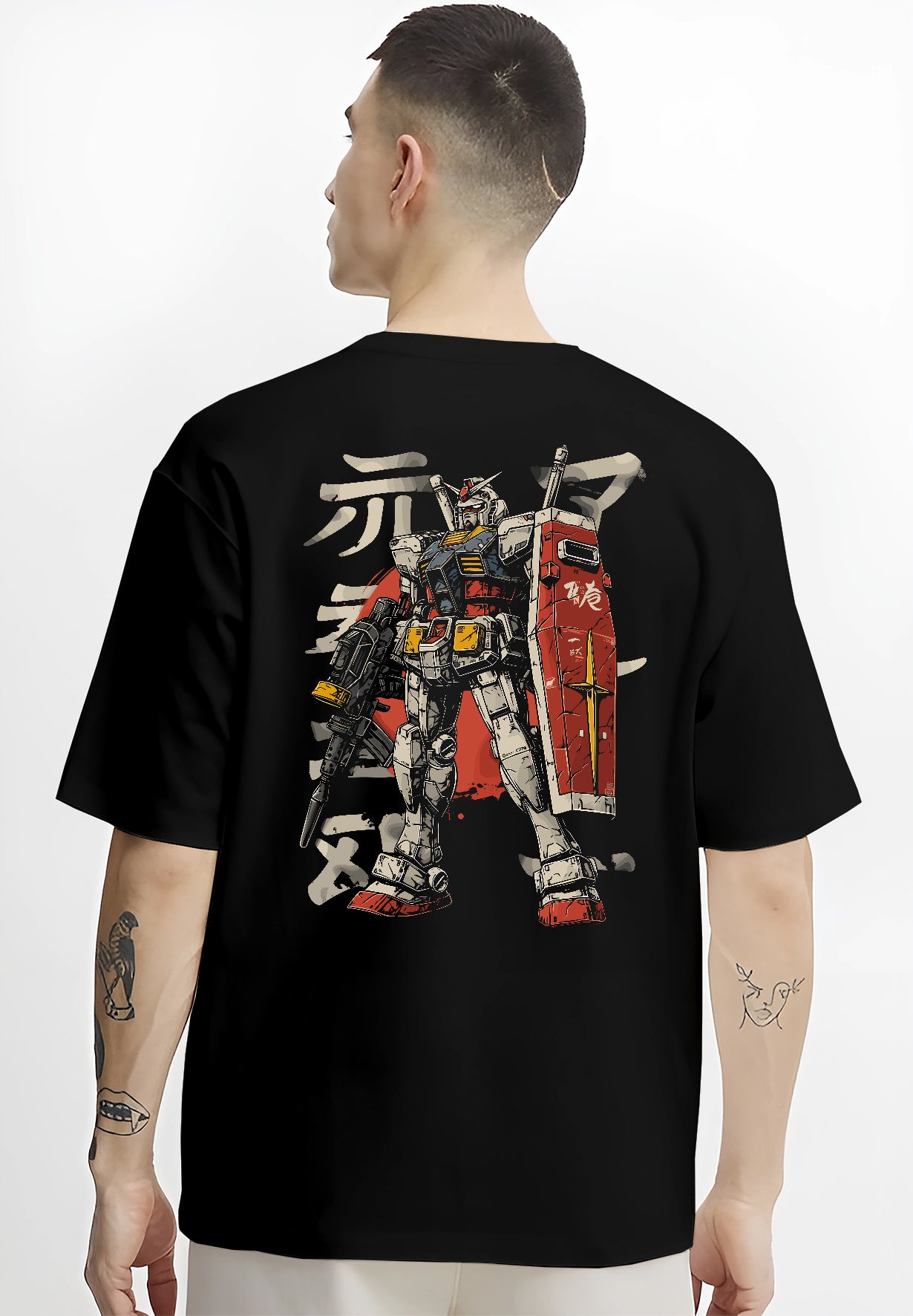 Black T-shirt worn by a male model, back view, featuring Gundam shonen battle mecha artwork with bold shield, rifle, and retro manga aesthetic in anime streetwear.