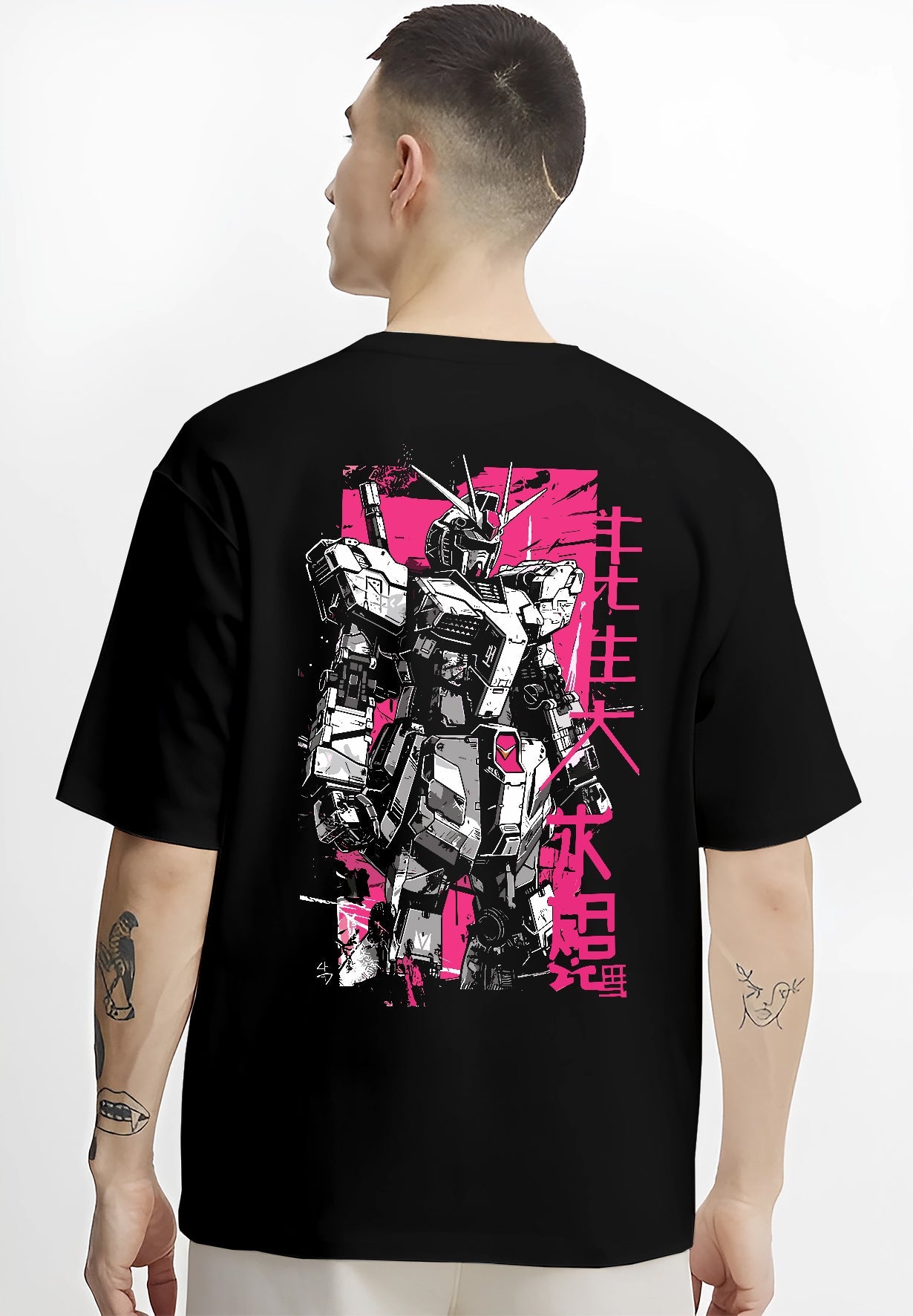 Black T-shirt on male model, back view, Gundam retro mecha artwork with pink poster backdrop and vertical Japanese characters.