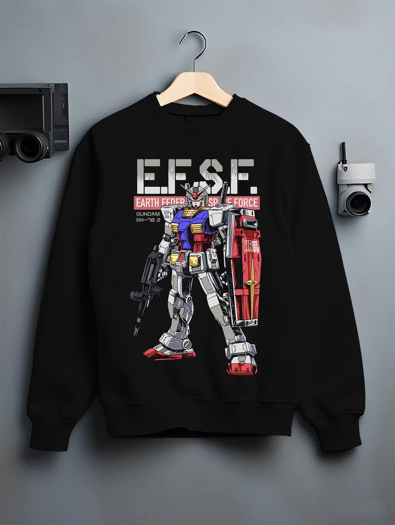 Black crewneck sweatshirt on hanger against grey wall, featuring Gundam RX-78-2 retro mecha back graphic with EFSF lettering, shield, and rifle.