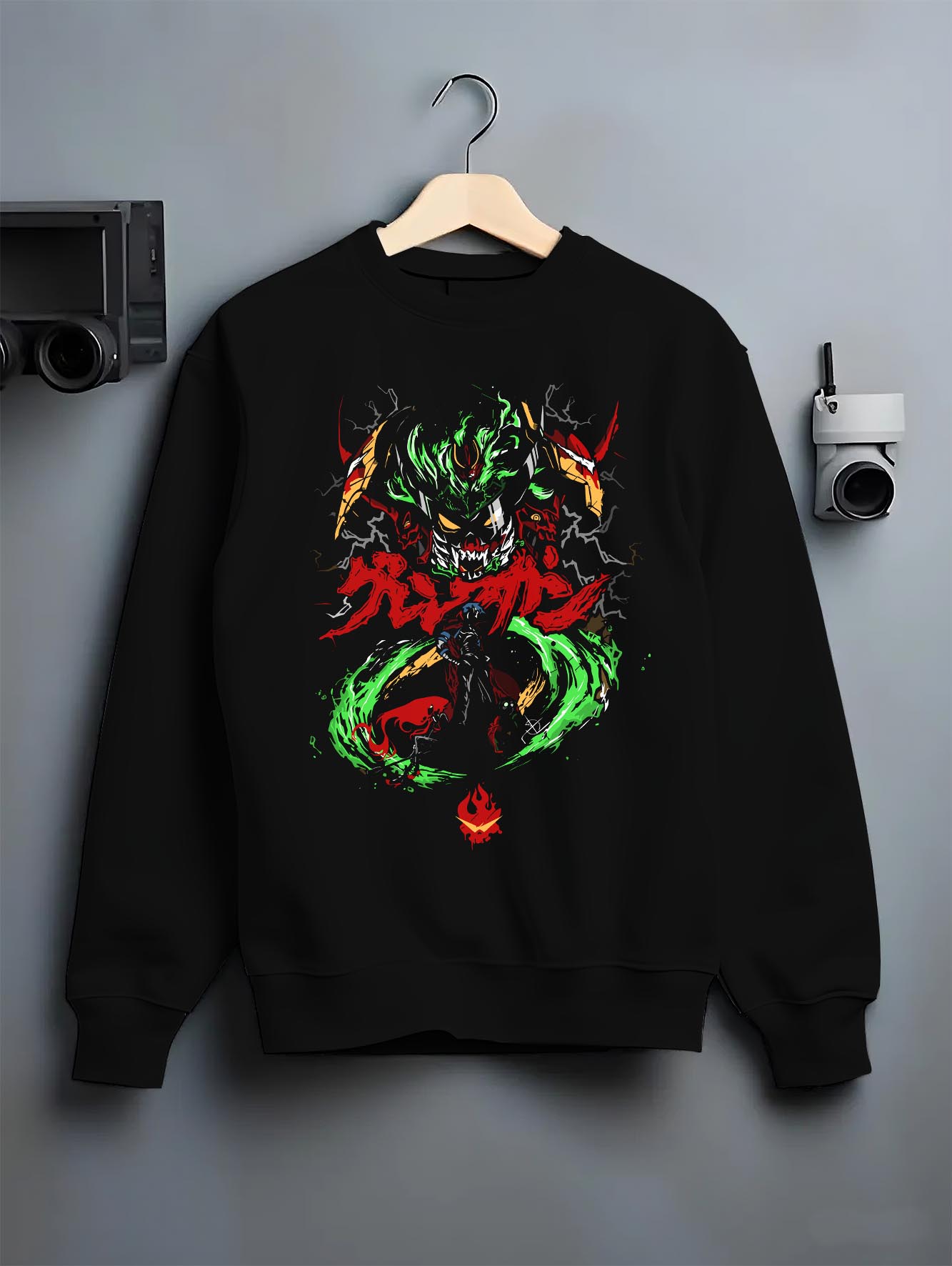 Black crewneck sweatshirt on a hanger against grey wall, featuring Gurren Lagann retro mecha graphic with green energy swirl and red kanji.