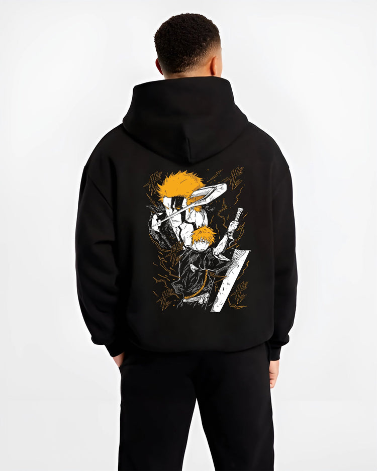 Black hoodie worn by a male model, back view, featuring Ichigo Bleach Japanese animation streetwear graphic with shonen battle character in striking orange sword pose.