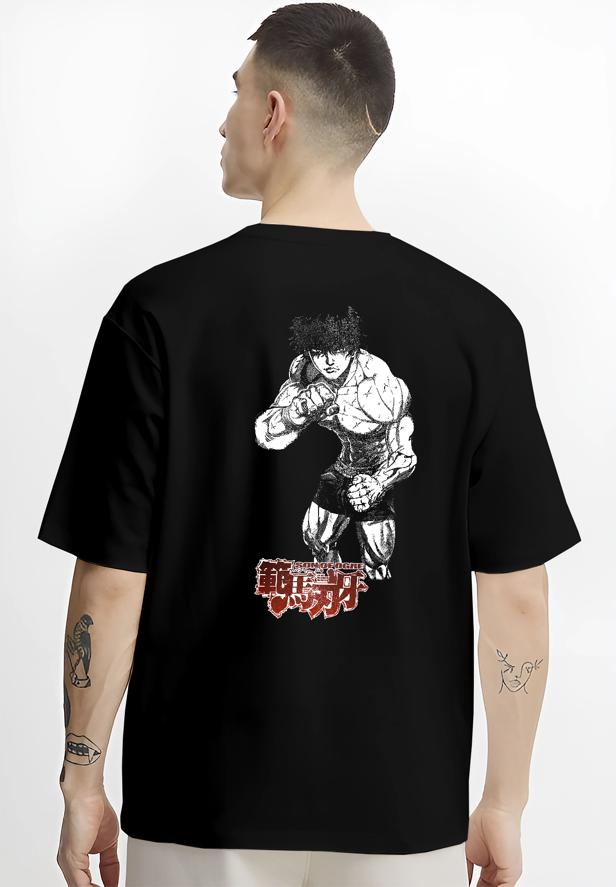 Black T-shirt worn by a male model, back view, featuring Baki Hanma Son of Ogre anime poster inspired graphic in bold retro manga artwork streetwear style.