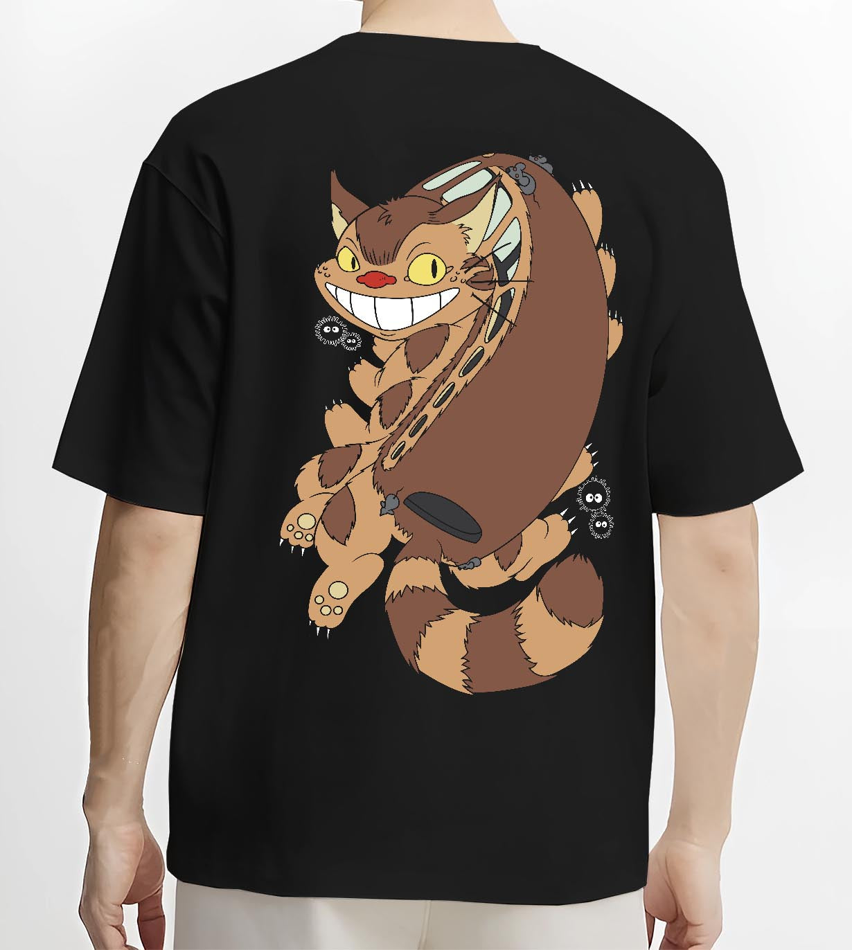 Black T-shirt worn by a male model, back view, featuring Totoro Catbus and soot sprites; casual retro graphic in Japanese animation style.