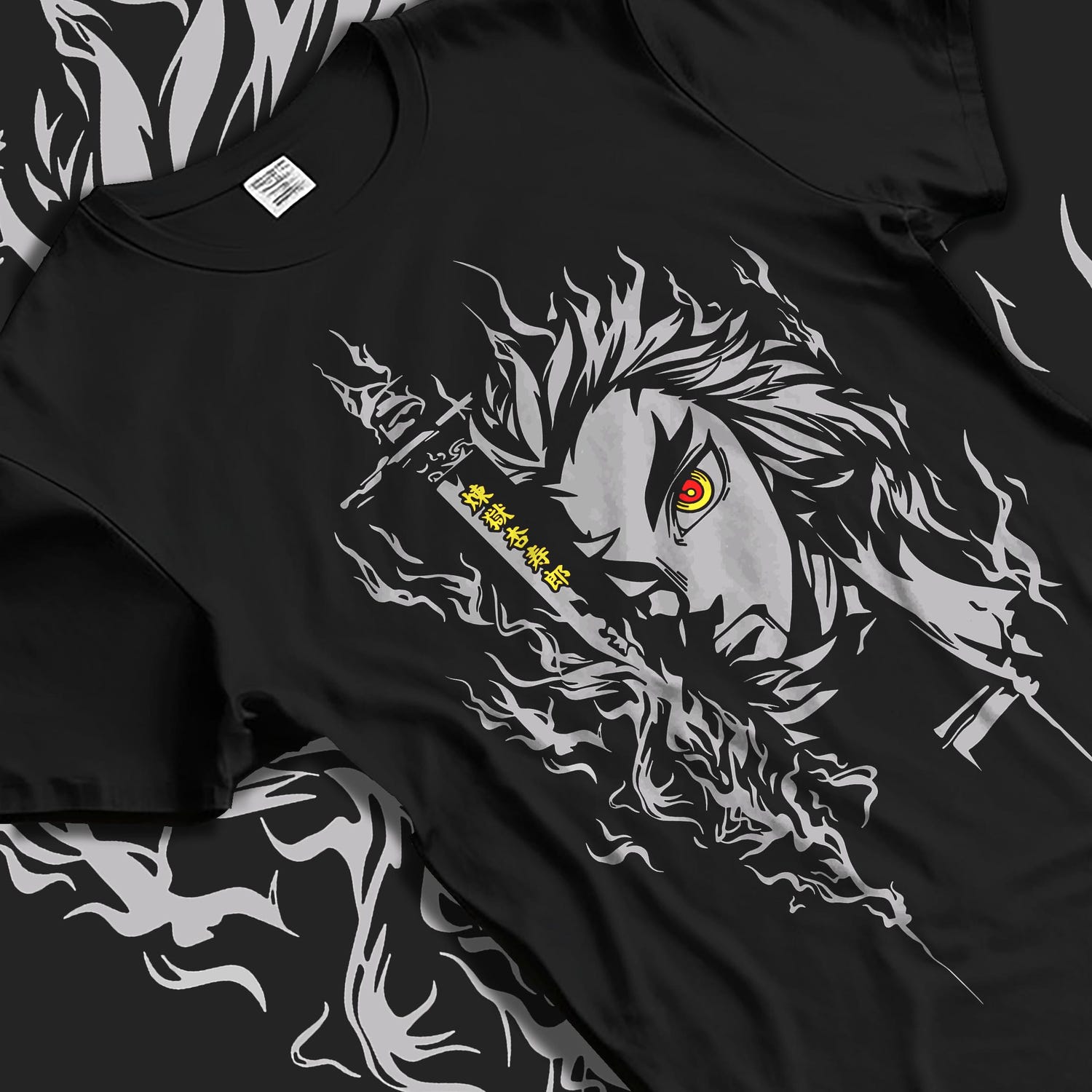 Black T-shirt laid flat with natural fabric folds, featuring Demon Slayer Rengoku anime poster inspired fiery portrait design with glowing red eye in manga graphic style.