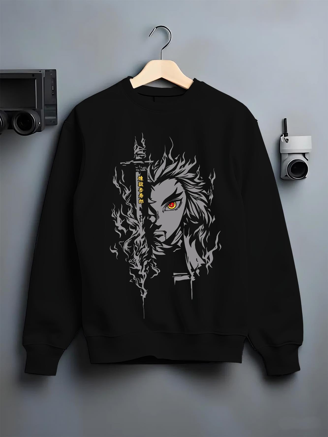 Black crewneck sweatshirt on a hanger against a grey wall, featuring Demon Slayer Rengoku anime poster inspired artwork with fiery aura in dark retro manga panel style.