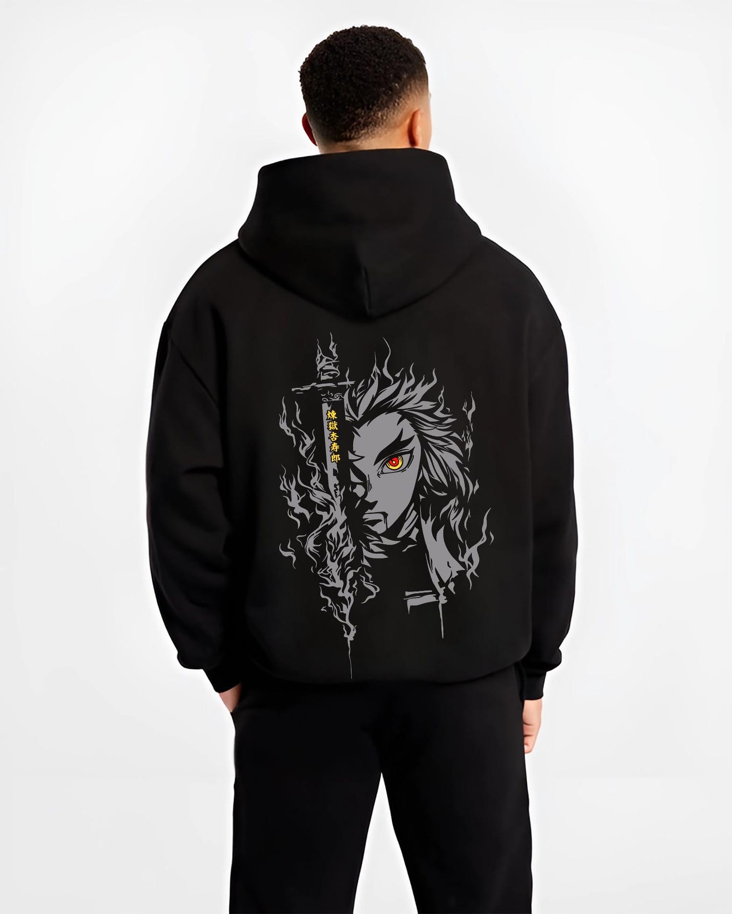 Black hoodie worn by a male model, back view, featuring Demon Slayer Rengoku anime poster inspired artwork with glowing red eye and fiery retro manga graphic style.