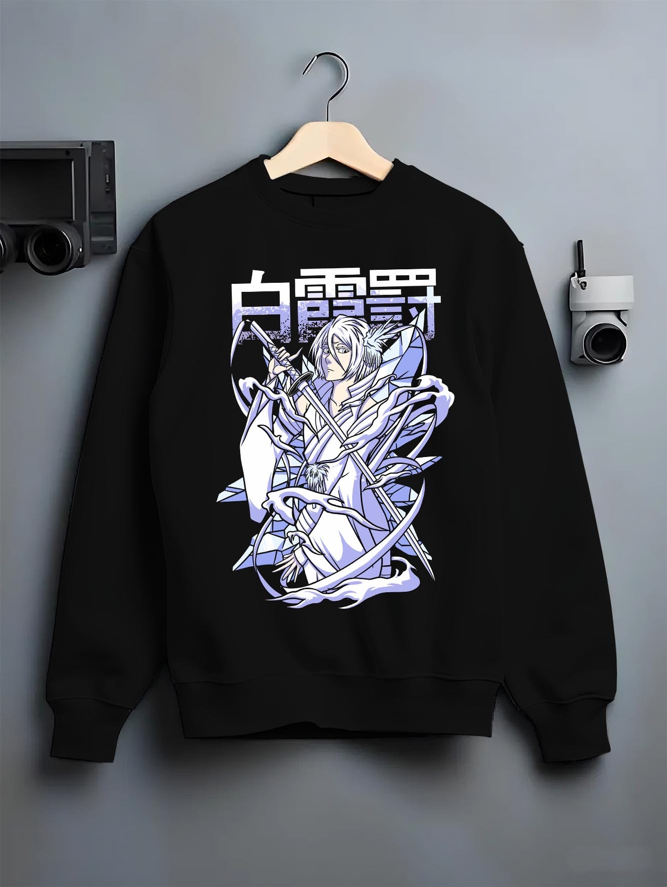 Black crewneck sweatshirt on a hanger against a grey wall, featuring Rukia Kuchiki Bleach Bankai icy retro manga poster inspired anime artwork