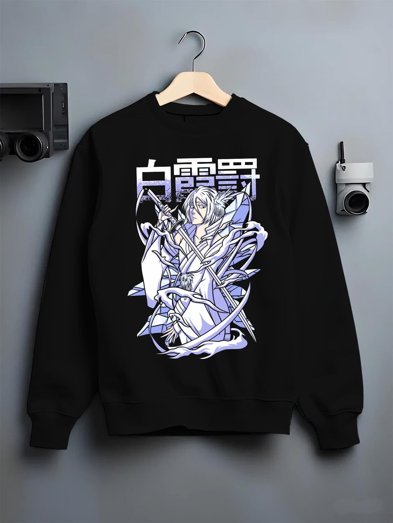 Black crewneck sweatshirt on a hanger against a grey wall, featuring Rukia Kuchiki Bleach Bankai icy retro manga poster inspired anime artwork