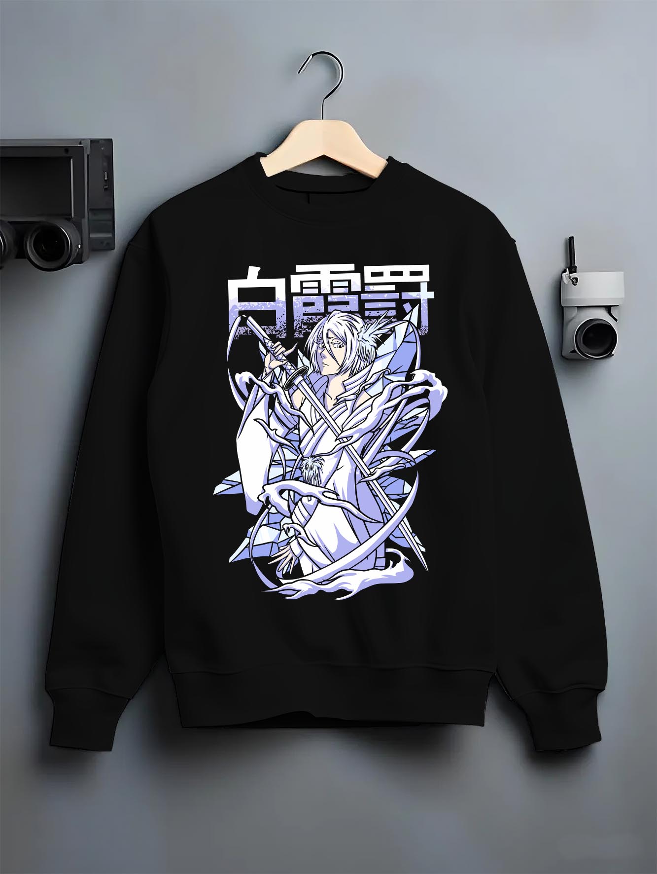 Black crewneck sweatshirt on a hanger against a grey wall, featuring Rukia Kuchiki Bleach Bankai icy retro manga poster inspired anime artwork