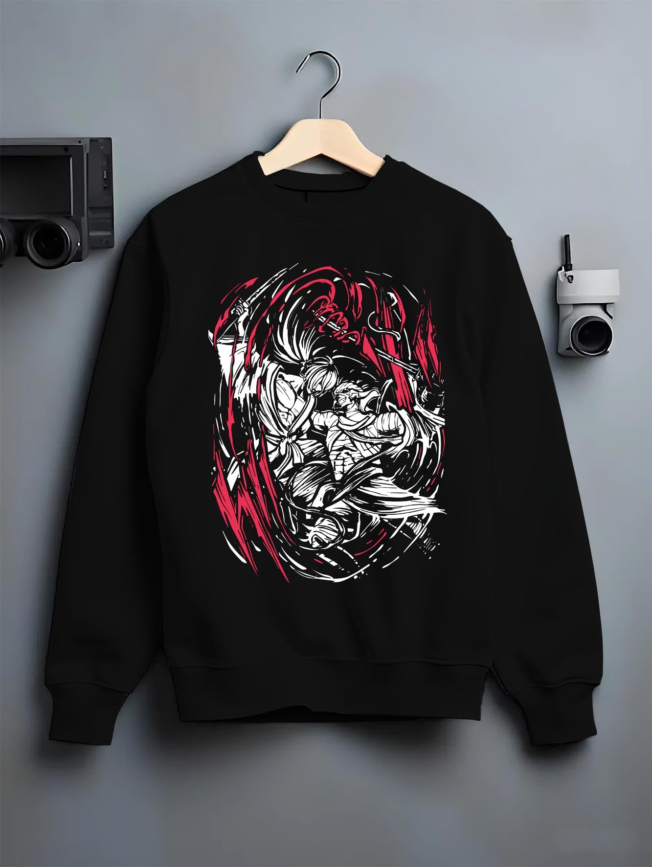 Black crewneck sweatshirt on hanger against grey wall, Rurouni Kenshin Samurai X back graphic with red slash accents.