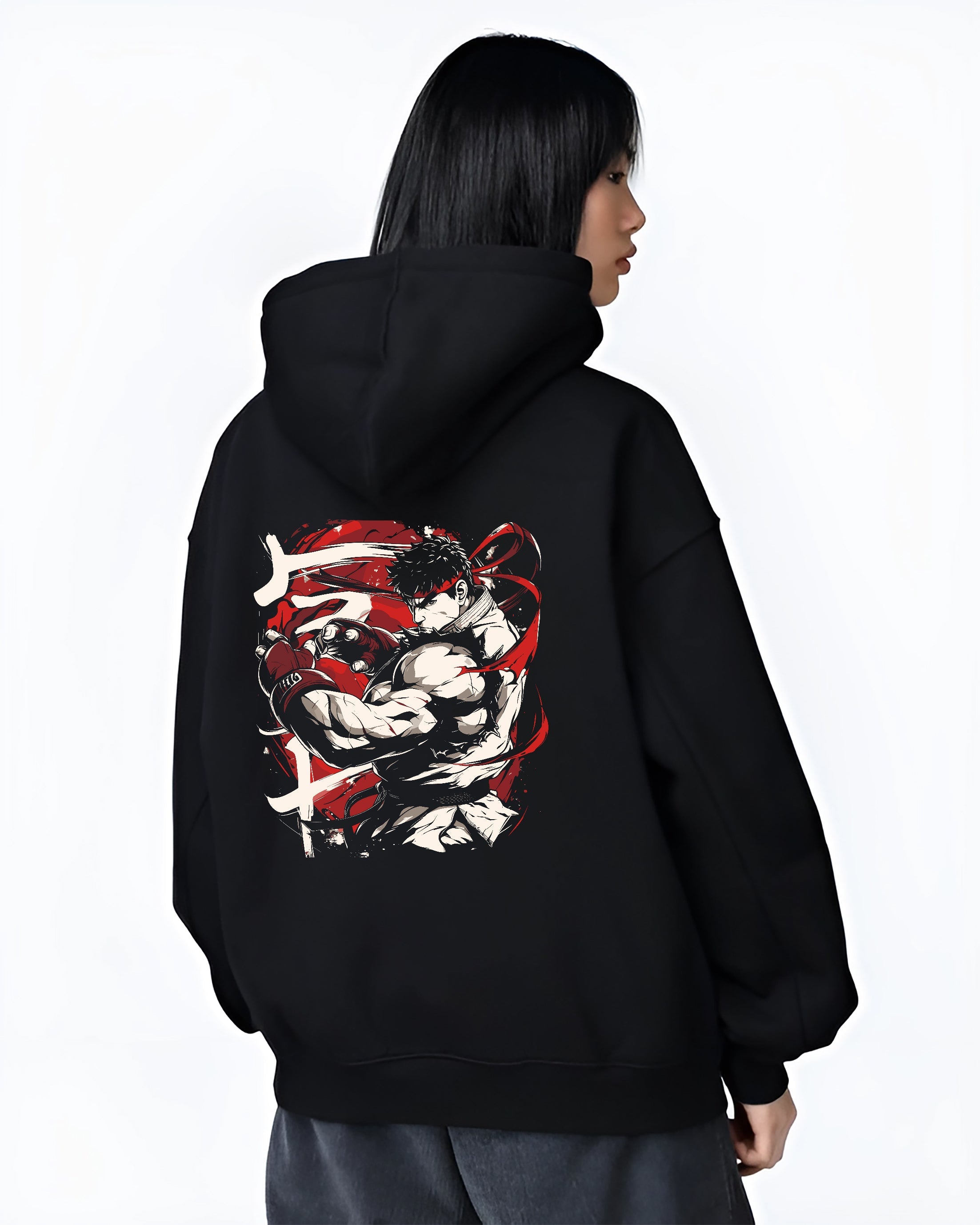 Black hoodie worn by a female model, back view, featuring Ryu Street Fighter Japanese animation streetwear graphic with focused fighter stance and dynamic red accents.