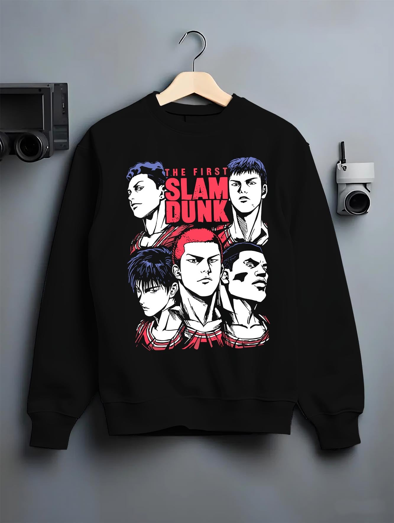 Black crewneck sweatshirt on hanger against grey wall, featuring Slam Dunk lineup retro manga graphic with red headline and modern streetwear flair.