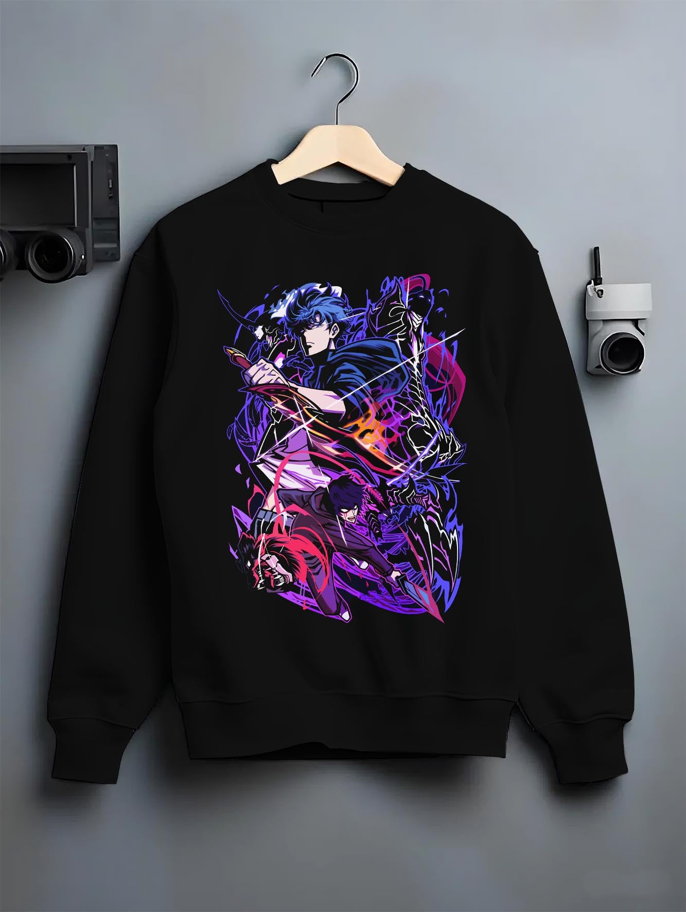 Black T-shirt laid flat with natural fabric folds, featuring Sung Jinwoo Solo Leveling anime poster inspired design with neon manga artwork and cyberpunk streetwear graphic