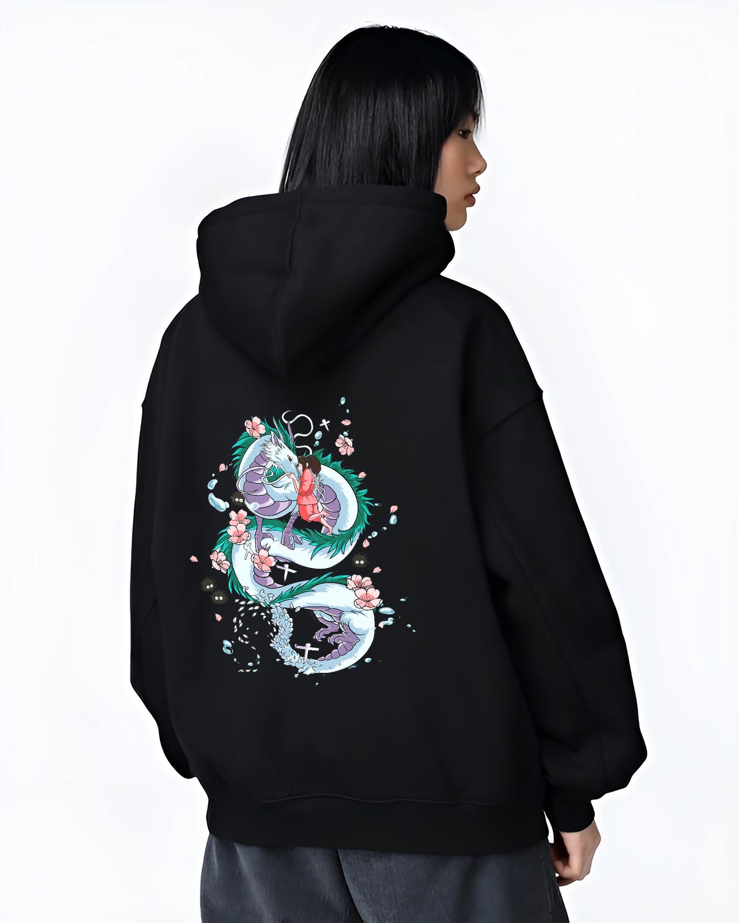 Black hoodie on female model, back view, featuring Spirited Away Haku and Chihiro nostalgic 90s graphic with petals and soot sprites.