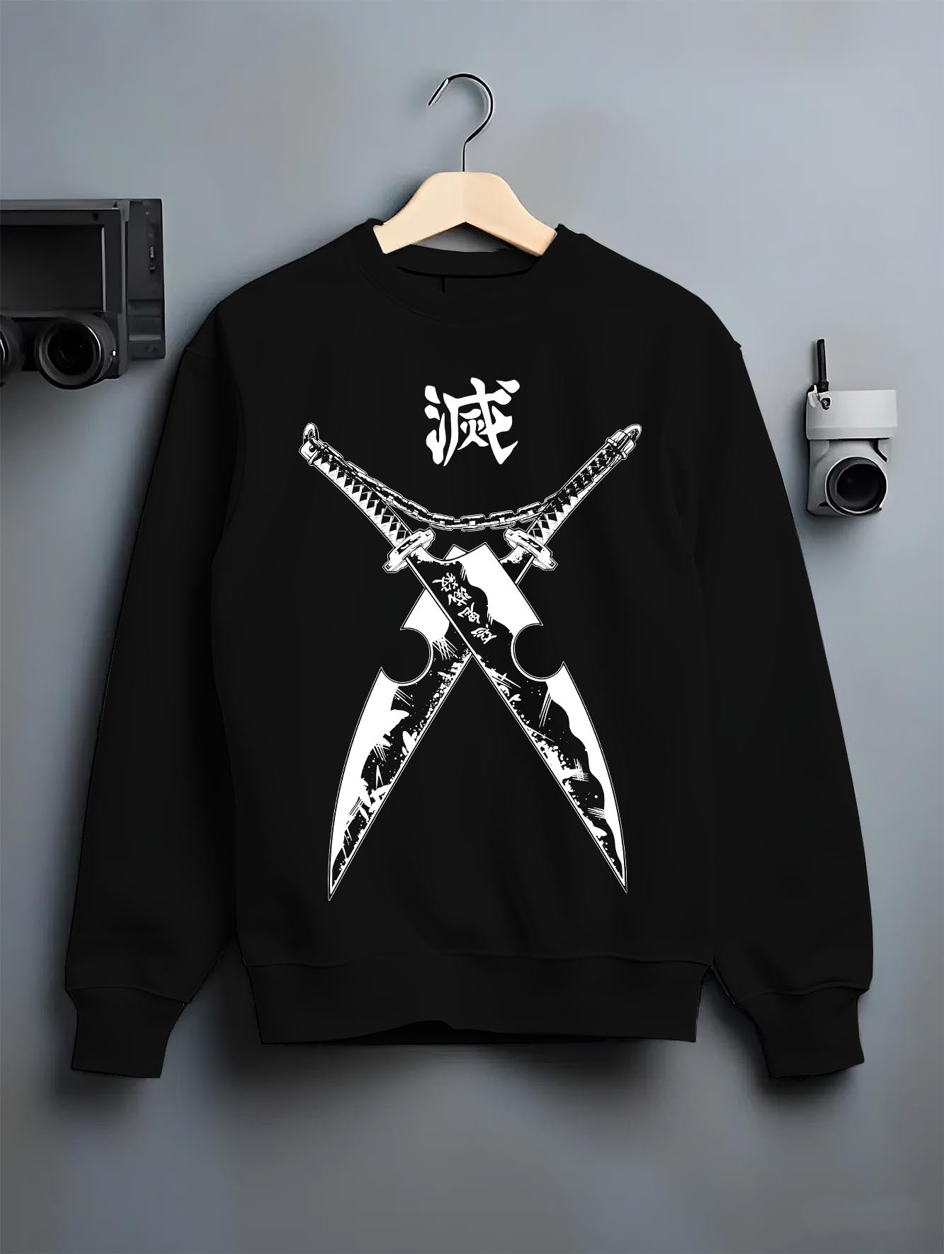 Black crewneck sweatshirt on hanger against grey wall, Tengen Uzui Demon Slayer crossed cleavers graphic with kanji header.
