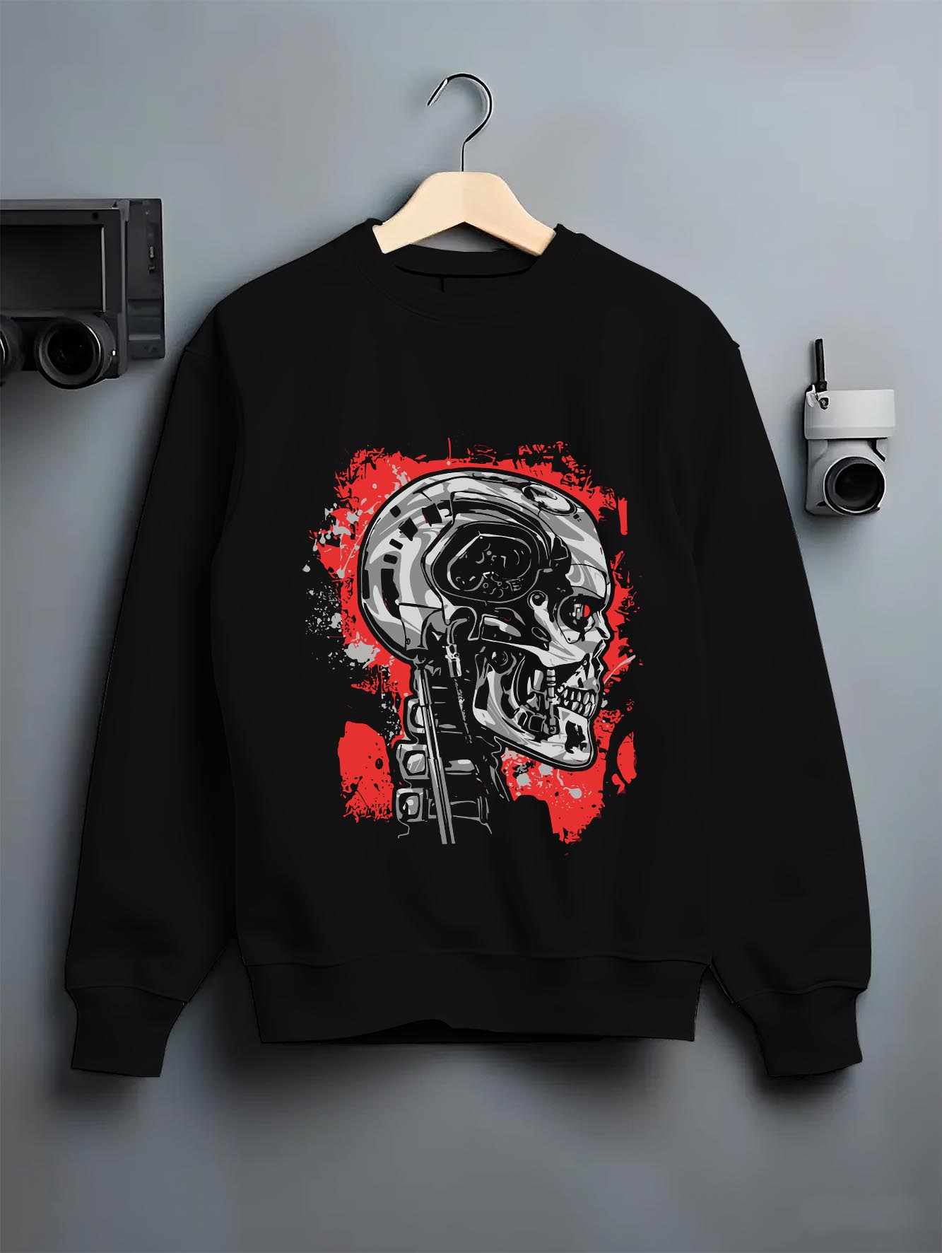 Black crewneck sweatshirt on hanger against a grey wall, featuring Terminator T-800 cyberpunk skull retro sci-fi graphic.
