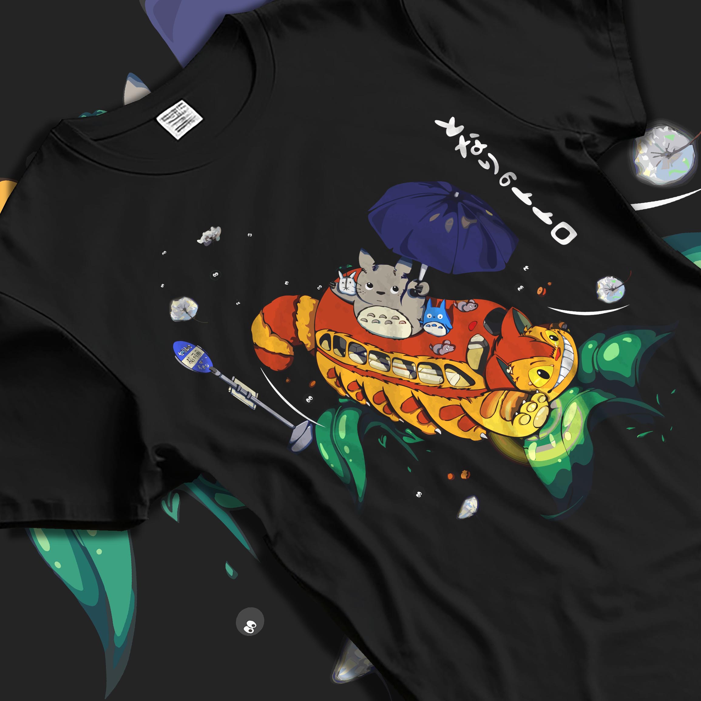 Black T-shirt laid flat with soft folds, featuring Totoro and Catbus retro manga design with umbrella and soot sprites.