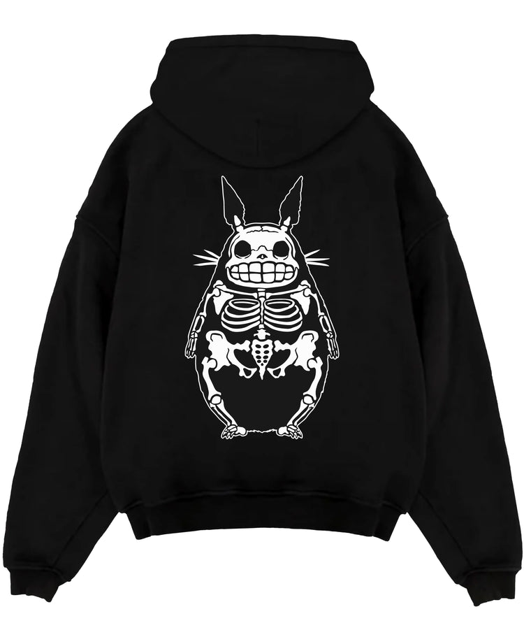 Black pullover hoodie laid flat on a white background, featuring Totoro skeleton x-ray silhouette in dark manga style minimalist streetwear graphic.
