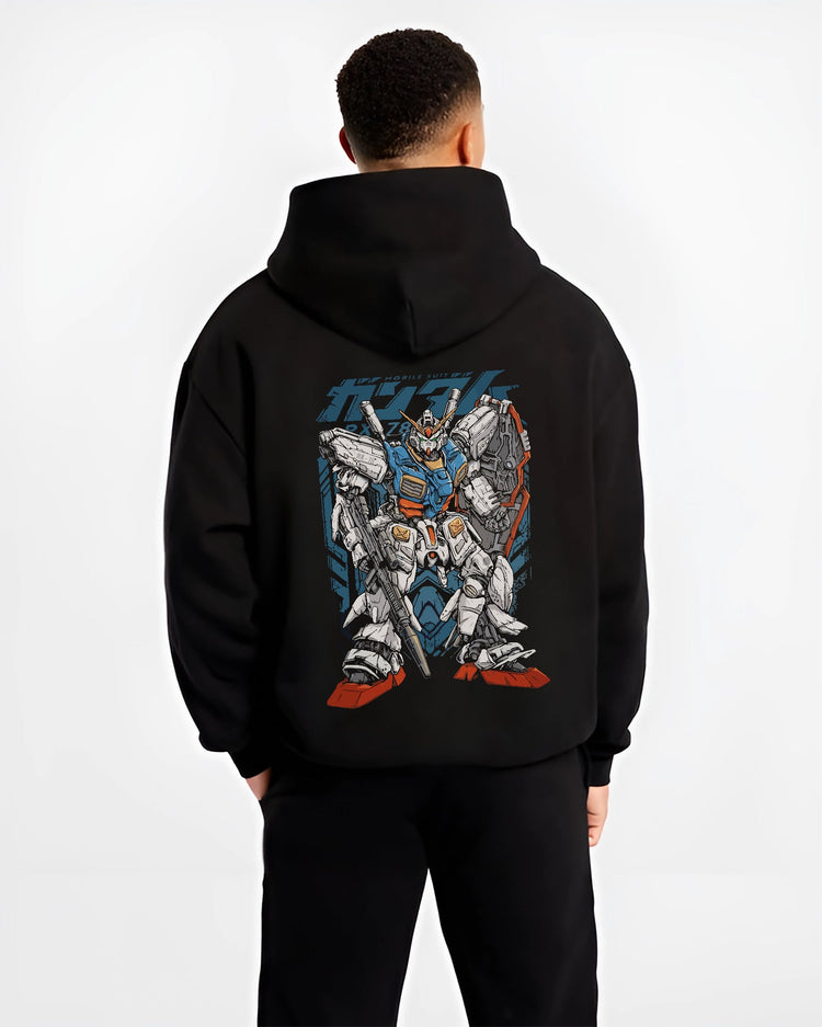 Black hoodie worn by a male model, back view, featuring Zeta Gundam anime poster inspired retro mecha artwork with bold Japanese animation streetwear graphic